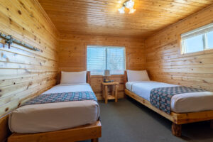 Bedroom with two beds and wood paneling